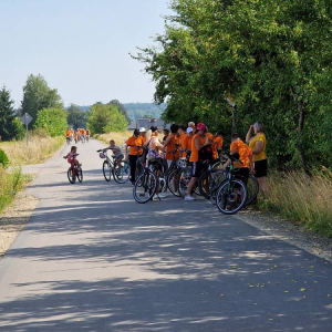 Na zdjęciu grupa uczesnuków rajdu rowerowego obpoczywająca w cieniu